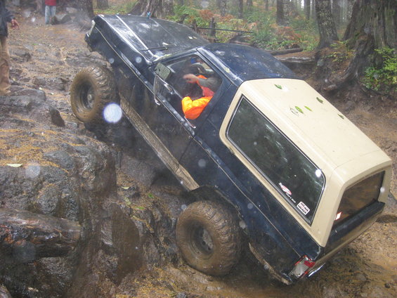 1979 Ford Bronco navigating a steep, muddy, rocky off-road trail