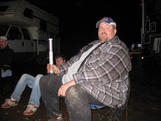 People sitting outdoors at night in front of RVs
