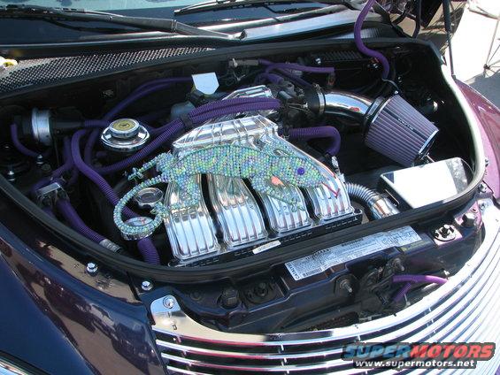 Engine bay of a 2005 Chrysler PT Cruiser with chrome intake manifold decorated with a jeweled lizard