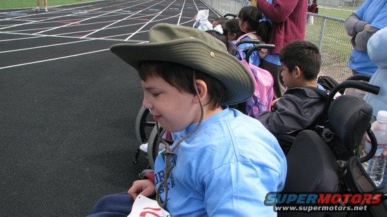 Children in wheelchairs watching a track event