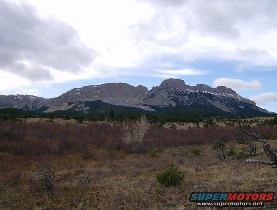 Mountain range with snow-capped peaks under a cloudy sky