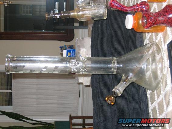 Glass bong with red and clear accents on a table