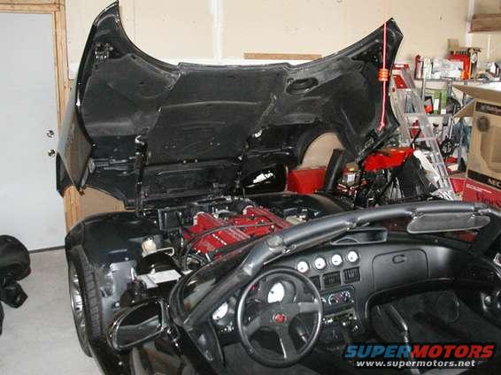 Black 1996 Dodge Viper convertible with hood open, showing red engine components and interior dashboard