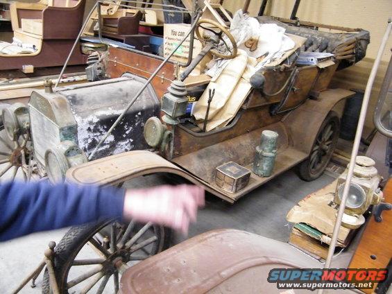 1909 Ford Model T, rusty brown, 3/4 front view, with wooden interior and spoked wheels