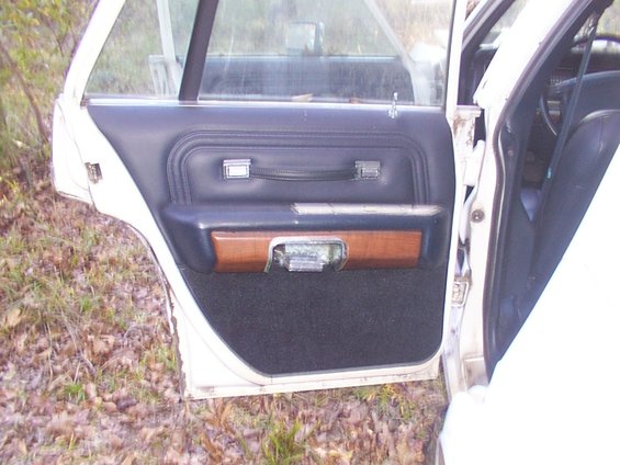 1991 Ford Crown Victoria LTD interior door panel with wood trim and black carpet