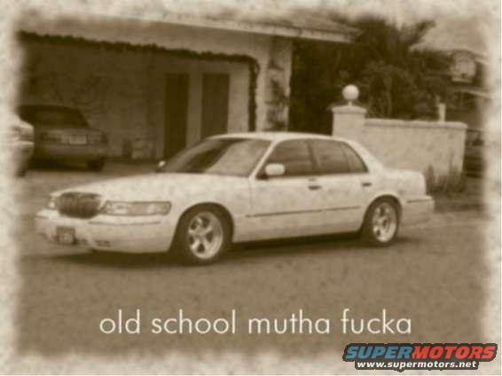 White Mercury Grand Marquis parked in front of a house. Text on image says 'old school mutha fucka'