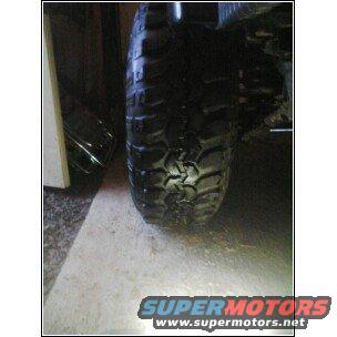 Close-up of a large, knobby off-road tire on a vehicle, likely a Jeep