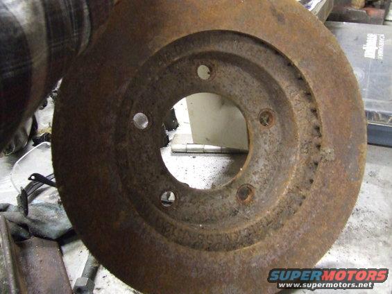 Rusty brake rotor with visible wear marks and bolt holes