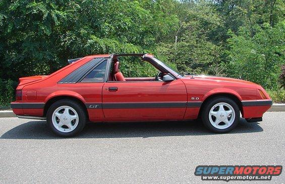 Red convertible sports car with GT and 5.0 badges, louvers on rear window