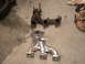 1990 Ford Probe - A comparison of a rusty exhaust manifold and a newly polished one sits on a garage floor.