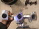 1990 Ford Probe - Close-up of an exhaust manifold being held, with another part on the floor.