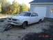 1970 Ford Ranchero - A white 1962 Pontiac Tempest sits on a dirt lot next to a garage.