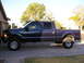 2001 Ford F-350 - Lifted 2001 Ford F-350 Super Duty crew cab pickup truck parked on a driveway.