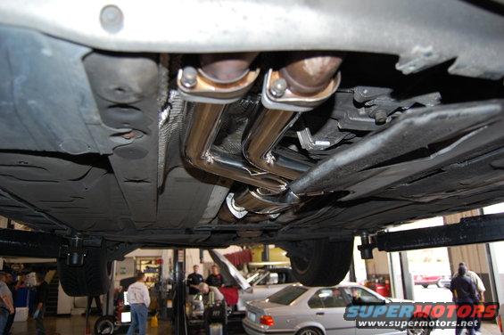 Underside view of a car's exhaust system, possibly aftermarket pipes