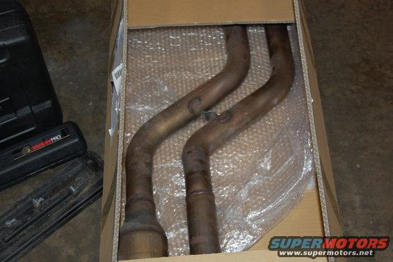 Exhaust pipes and catalytic converter in a cardboard box with bubble wrap