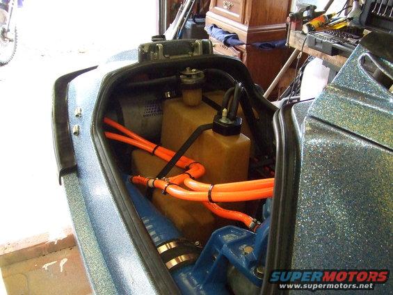 Jet ski engine compartment with orange hoses and tan tanks
