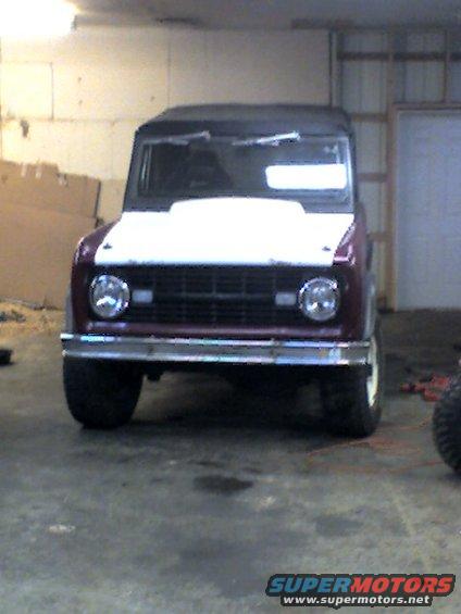 1968 Ford Bronco front view, maroon body with white hood, in a garage