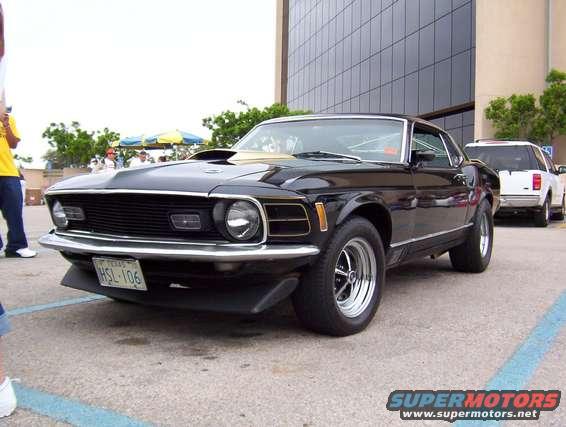 Black 1970 Ford Mustang coupe with gold trim, front 3/4 view. Texas license plate HSL-106
