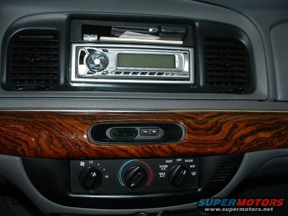 Car dashboard with wood trim, aftermarket stereo, and climate controls