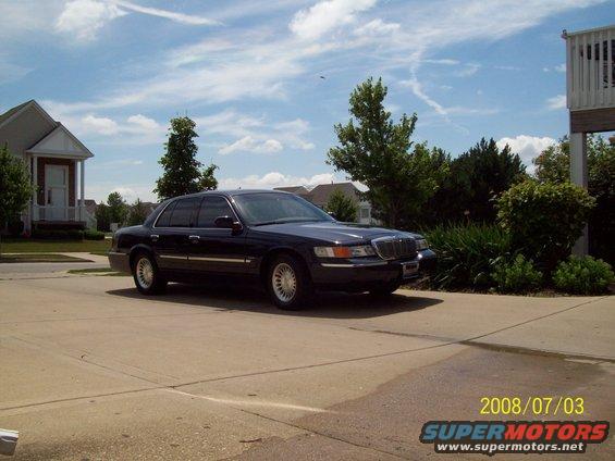 Dark blue Mercury Grand Marquis parked in a driveway on a sunny day