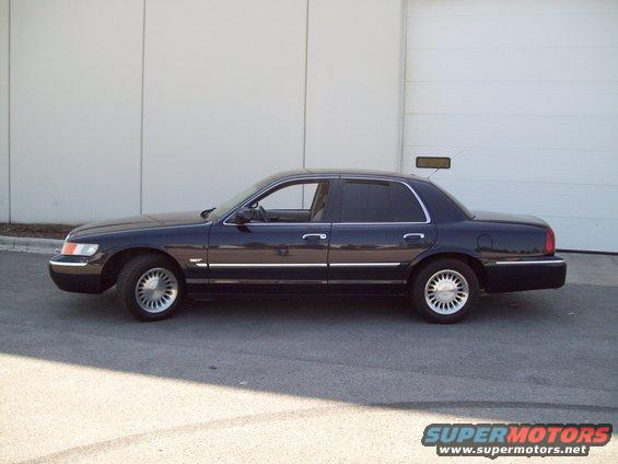 dark sedan parked outside a building, side view
