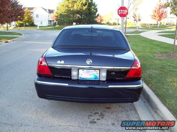 Dark blue Mercury Grand Marquis parked on a residential street, rear view. Has a "4.6" badge and Illinois plates