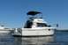 1985 Carver 326 Aft Cabin - A white motor yacht named Drifter is docked on blue water under a clear sky, with another boat visible to the left.