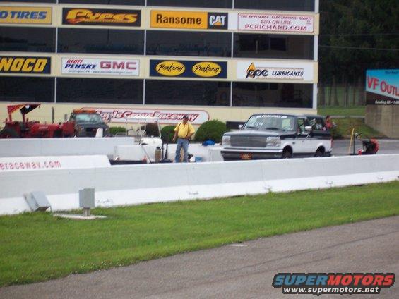 Two-tone black and white Ford F-Series truck on a drag strip, front grille visible