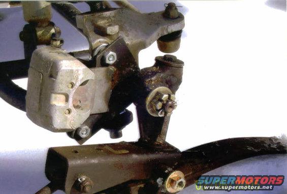 Close-up of vehicle suspension parts, including a brake caliper and linkage