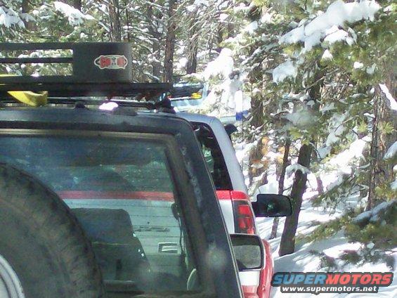 Black SUV with roof rack in snowy forest