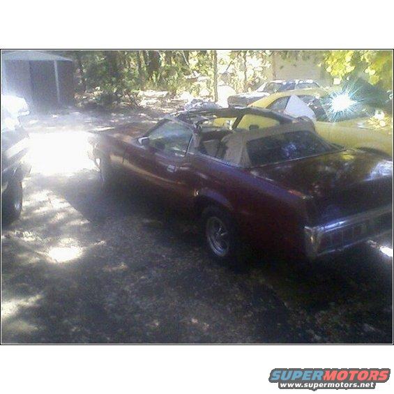 maroon convertible parked outside, another yellow car behind it