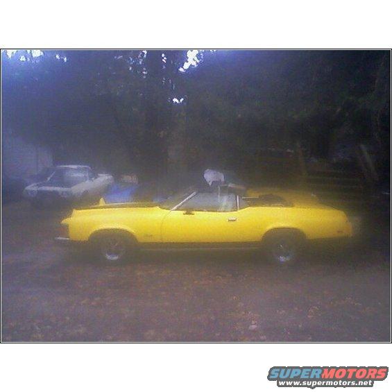 Yellow 1973 Mercury Cougar convertible, side view, with another car behind it