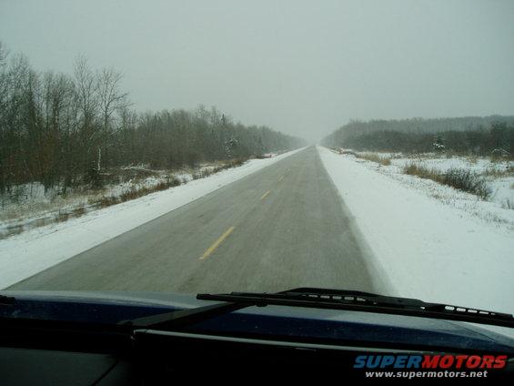Interior view of car dashboard and windshield on a snowy road