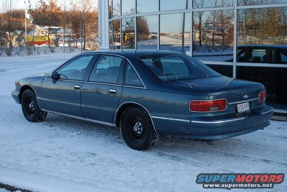 Dark blue sedan with black wheels parked in snow. License plate reads BUX 488