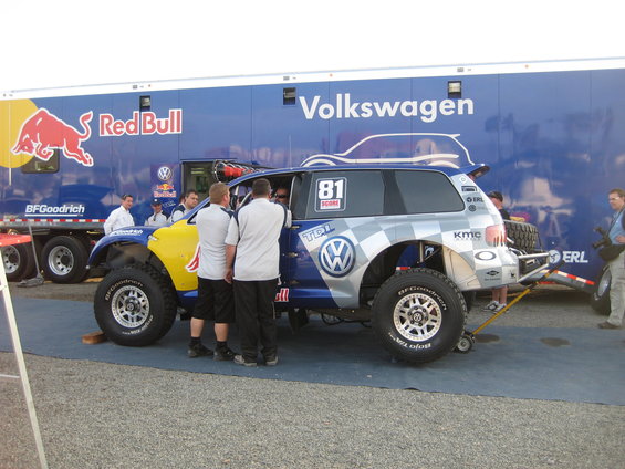 Volkswagen Touareg race truck with Red Bull and BFGoodrich livery, parked in front of a Volkswagen trailer