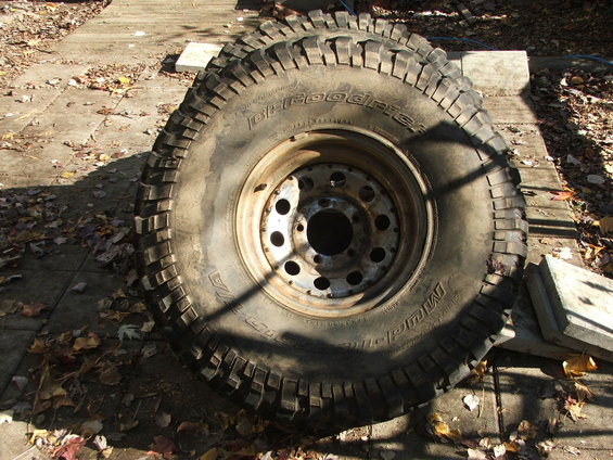 Two BFGoodrich Mud-Terrain T/A tires with metal rims on a concrete surface