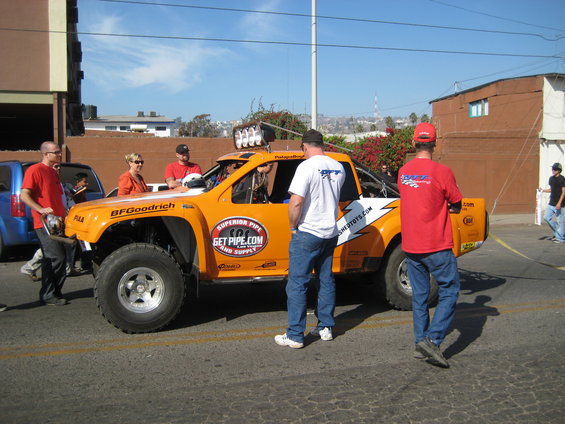 Orange off-road race truck with BFGoodrich tires and 'GET PIPE.COM' graphics