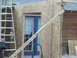 2005 Ford Mustang - A construction project is underway, with a ladder leaning against a wooden structure and plywood covering a doorway.