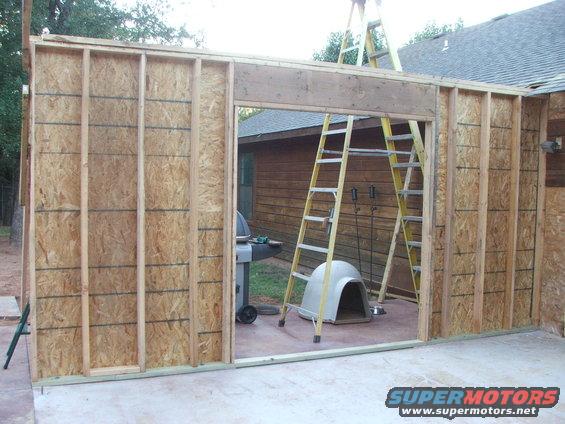 Framing for a new structure is up, with ladders and a dog house visible inside