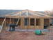 2005 Ford Mustang - A backyard construction project is underway, an unfinished patio roof and various building materials.