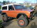 1972 Ford Bronco - This 1972 Ford Bronco features a distinctive orange paint job, a white hardtop, and aggressive off-road tires.
