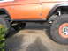 1972 Ford Bronco - Side profile of an orange 1972 Ford Bronco with off-road tires and fender flares.