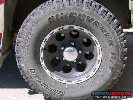 Close-up of a Cooper Discoverer S/T tire on a black wheel with chrome accents