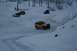 1990 Chevrolet Suburban - Several SUVs navigate a snowy landscape with trees in the background.