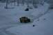 1990 Chevrolet Suburban - Two SUVs navigate a snow-covered landscape, one yellow and equipped with a roof rack.