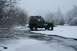 1990 Chevrolet Suburban - A Jeep navigates a frozen landscape with snow-covered trees and a mountain in the background.
