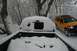 1990 Chevrolet Suburban - A yellow SUV is parked on a snow-covered road next to a pickup truck also covered in snow.