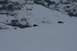 1990 Chevrolet Suburban - Two vehicles traverse a snowy mountain landscape with a few people observing.