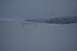1990 Chevrolet Suburban - A vast, snow-covered landscape stretches towards , mist-shrouded mountains under an overcast sky.