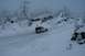 1990 Chevrolet Suburban - A white Jeep Wrangler navigates a snow-covered road surrounded by trees laden with snow.